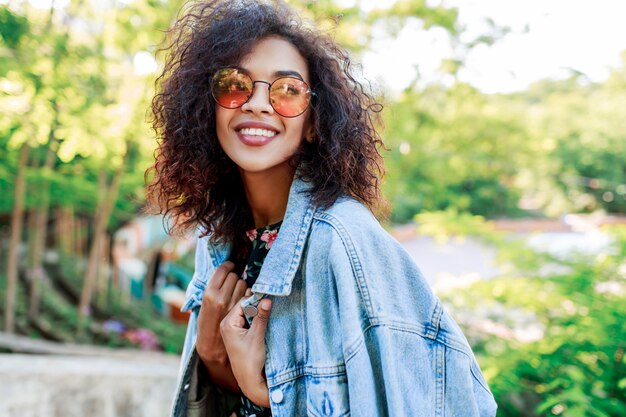 Carrera mezclada, mujer hermosa, con, perfecto, dientes y pelos, pasar su ocio, en el estacionamiento