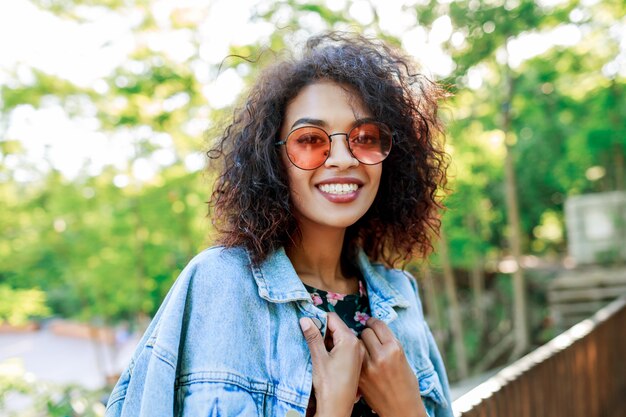 Carrera mezclada, mujer hermosa, con, perfecto, dientes y pelos, pasar su ocio, en el estacionamiento