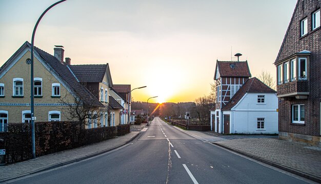 Carretera asfaltada en el paisaje rural de la ciudad y la puesta del sol