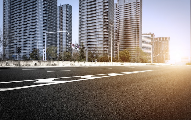 Carretera de asfalto vacía con edificios de fondo