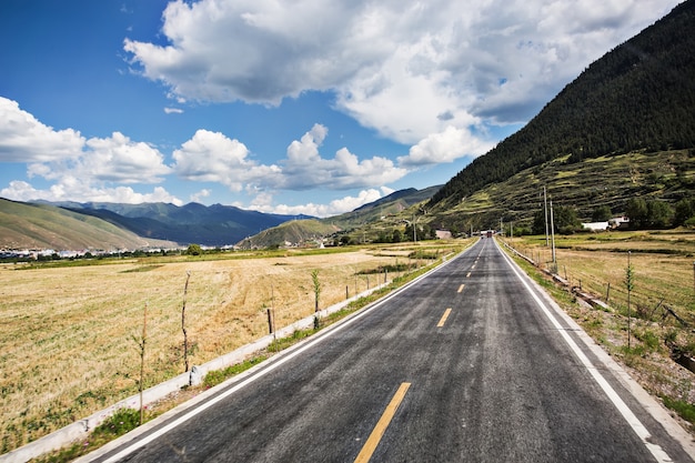 Carretera con un cielo con nubes blancas