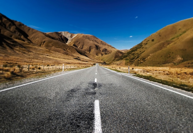 Carretera continua en un paisaje escénico con cordilleras lejos.