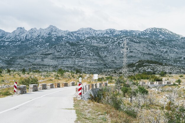 Carretera curva vacía a Mali Halan, sur de Velebit, serpenteante a través de montañas rocosas