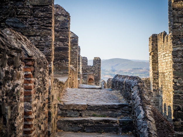 Carretera estrecha en las grandes murallas de un antiguo castillo - concepto de fondo