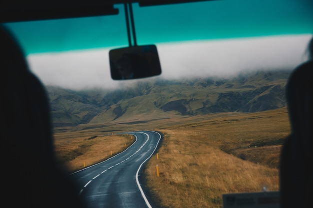 Foto gratuita carretera estrecha en un hermoso gran campo de tiro desde el interior del automóvil