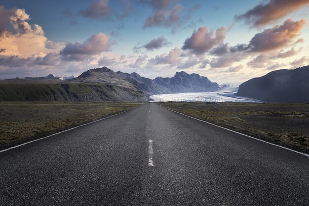 Carretera estrecha que conduce a altas montañas rocosas en el Parque Nacional Skaftafell en Islandia