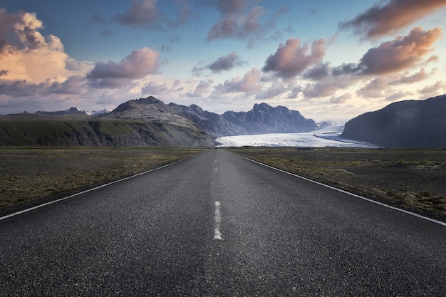 Carretera estrecha que conduce a altas montañas rocosas en el Parque Nacional Skaftafell en Islandia