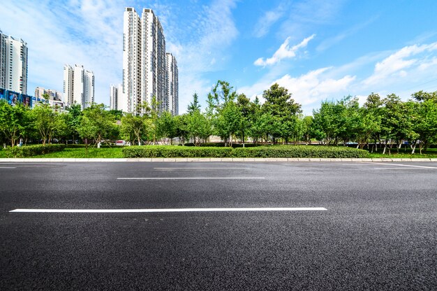 Carretera con un fondo de edificios y parque