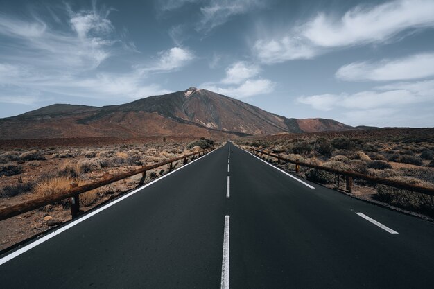 carretera rodeada de colinas bajo el cielo nublado