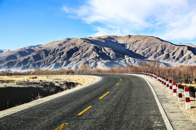 Carretera solitaria con montañas en el horizonte