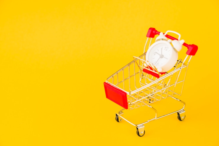 Foto gratuito carrito de compras con pequeño reloj despertador.
