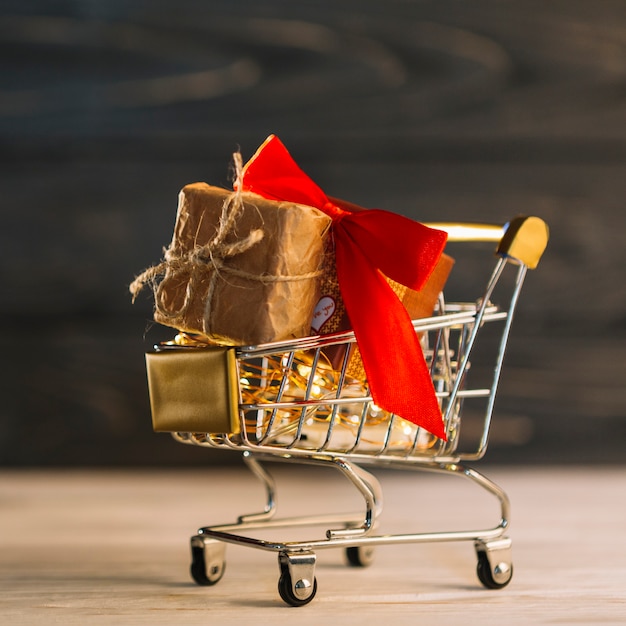 Carrito pequeño con caja de regalo con banda roja.