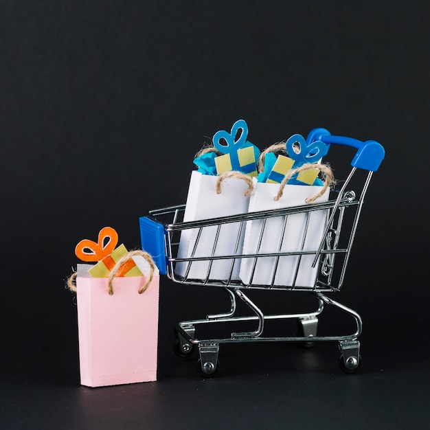 Carrito de supermercado de juguete con regalos en paquetes.