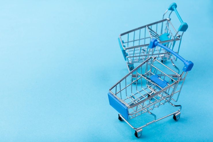 Foto gratuito carritos de compras sobre fondo azul con espacio de copia
