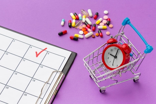 Foto gratuita carro de juguete con reloj y pastillas al lado del escritorio