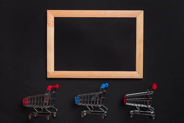 Carros de la compra con asas rojas y azules y marco de fotos.