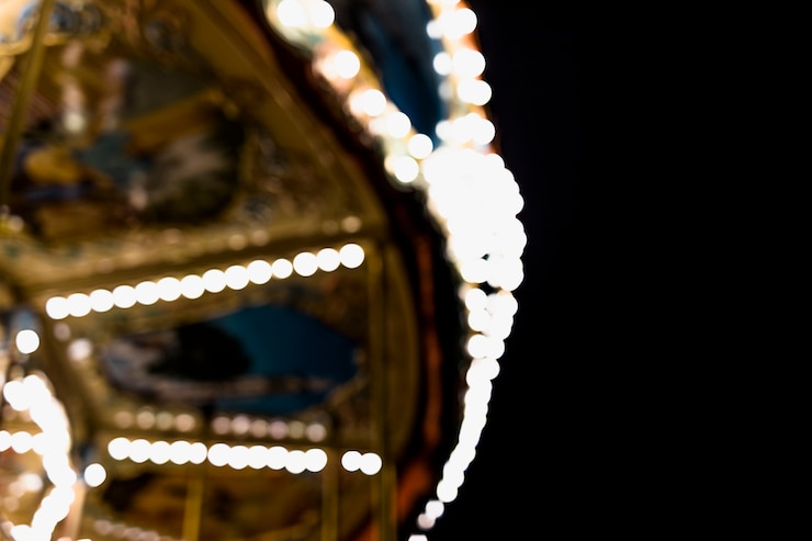 Foto gratuito un carrusel borroso en el parque de atracciones contra el fondo negro