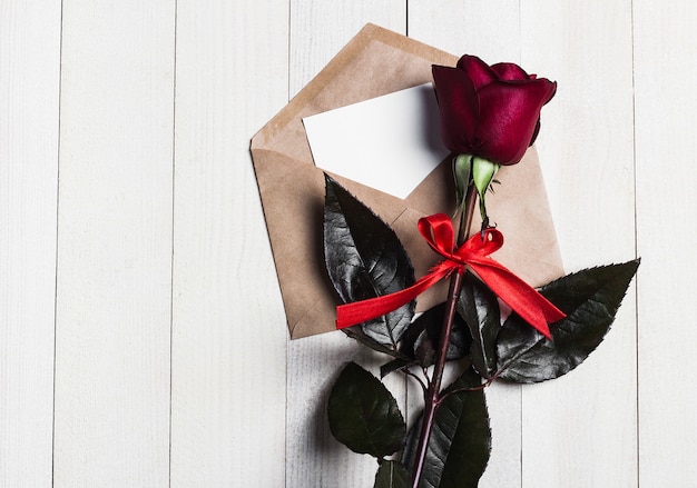 Foto gratuita carta de amor del sobre del día de san valentín con rosa roja del día de madres de la tarjeta de felicitación