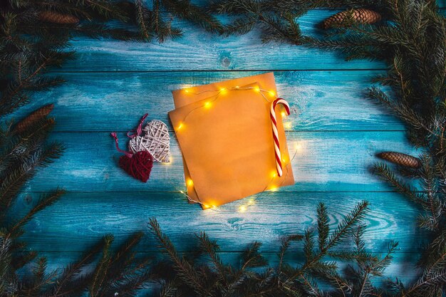Carta de Navidad a Santa en una mesa azul de madera. Guirnalda iluminada. Bosquejo.