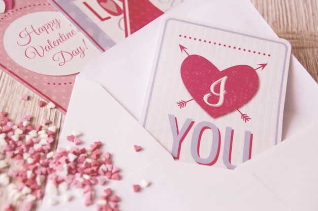 Foto gratuita carta con una postal con un corazón y caramelos con forma de corazón