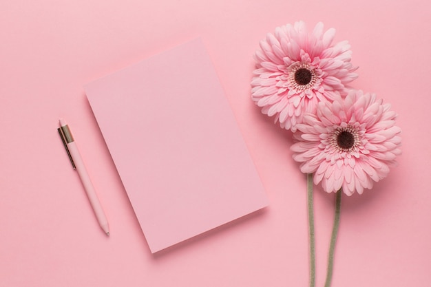 Carta rosa con flores rosas y bolígrafo