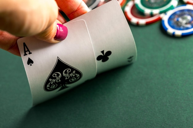 Cartas y fichas de póquer en mesa verde