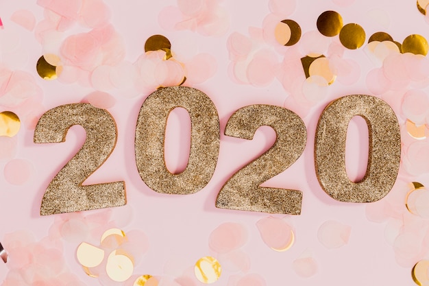Cartel de año nuevo con confeti dorado y rosa
