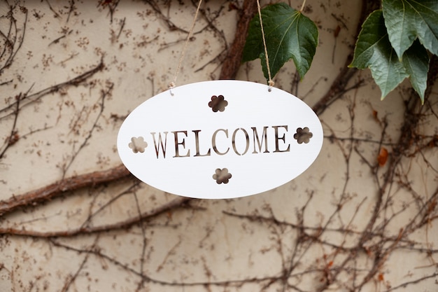 Cartel de bienvenida con planta al aire libre