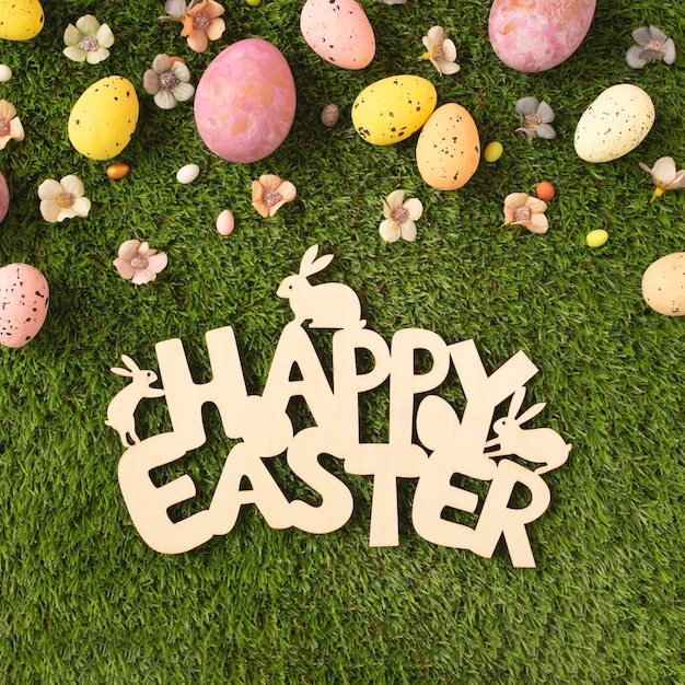 Foto gratuita cartel de madera de feliz pascua con huevos y flores