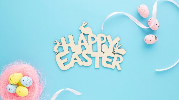 Cartel de madera de Pascua feliz con huevos sobre un fondo azul.