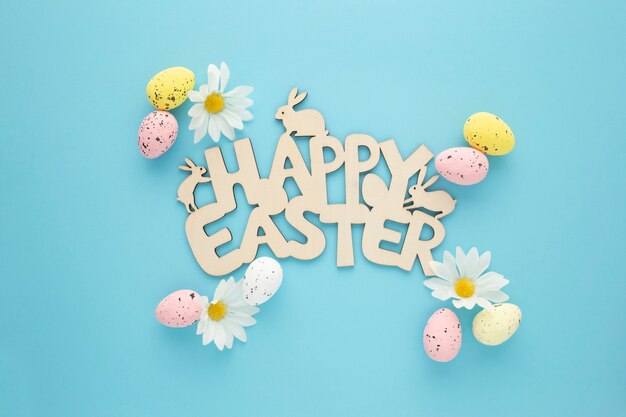 Cartel de Pascua feliz con huevos y margaritas sobre un fondo azul.