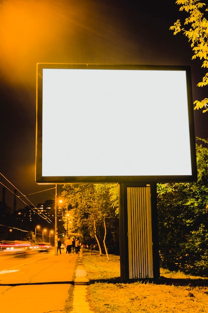 Cartelera en blanco en la carretera de la ciudad por la noche