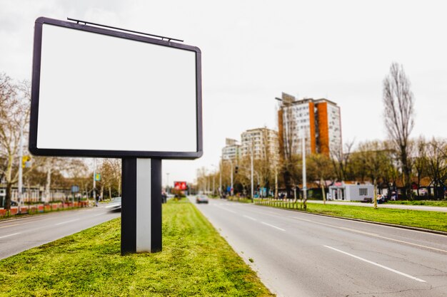 Cartelera en blanco en carretera en ciudad útil para publicidad