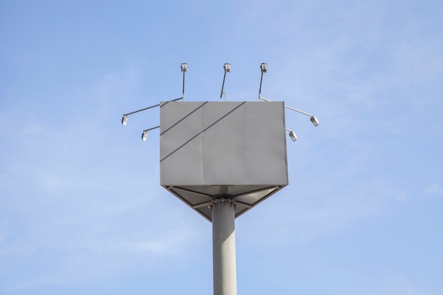 Cartelera en blanco con luces contra el cielo azul