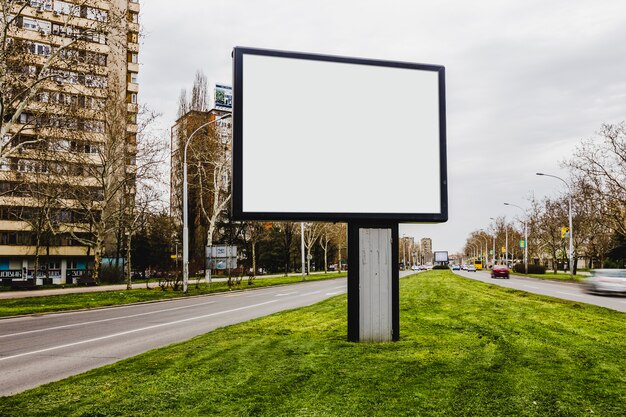 Cartelera de la ciudad en blanco en el camino en medio de la carretera