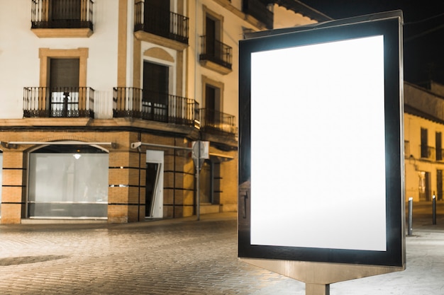 Cartelera de luz iluminada cerca del edificio de apartamentos