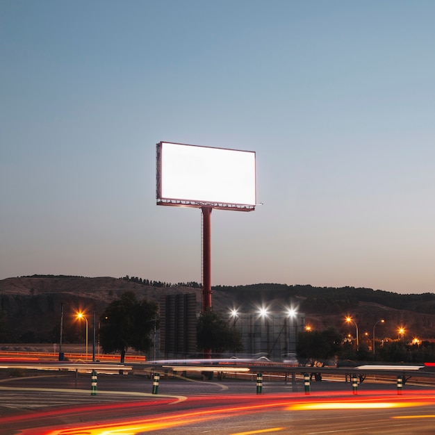 Carteles publicitarios en blanco en la carretera iluminada por la noche