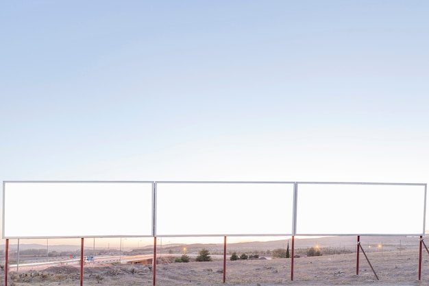 Carteles publicitarios en blanco cerca de la carretera contra el cielo azul