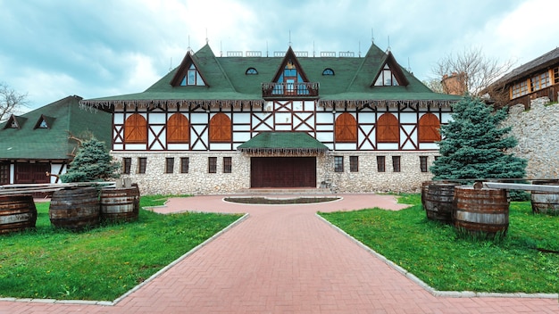 Casa antigua de estilo nacional rumano. Patio verde en primer plano
