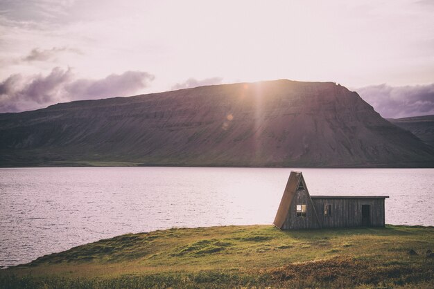 Casa cerca del lago bajo un cielo blanco