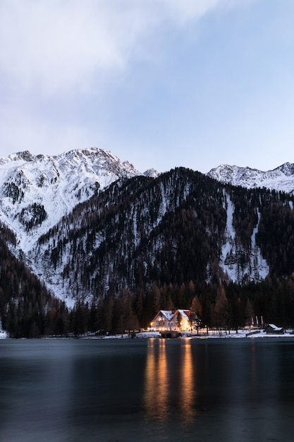 Foto gratuita casa entre cuerpo de agua y montaña