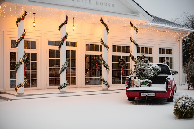Foto gratuita casa decorada para navidad con coche rojo