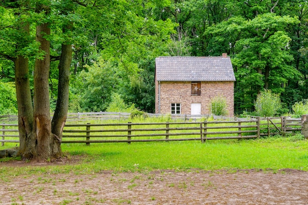 Casa de ladrillo entre árboles verdes en el museo al aire libre en la aldea de Kommern, zona de Eifel, Alemania