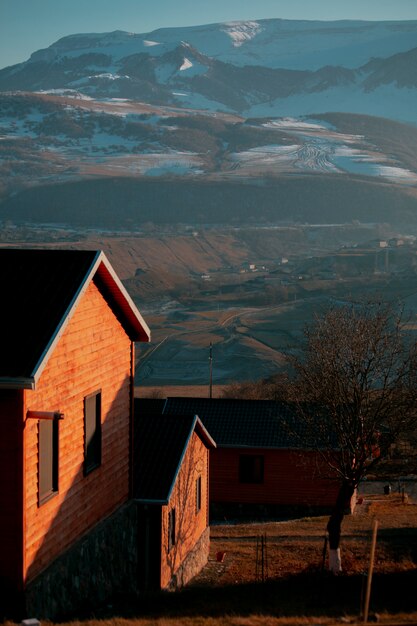 Casa de ladrillo a través de montañas nevadas