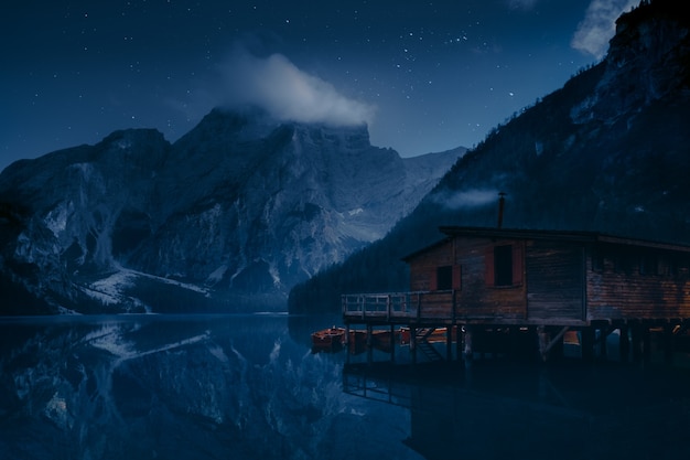 Casa de madera marrón en el lago cerca de la montaña