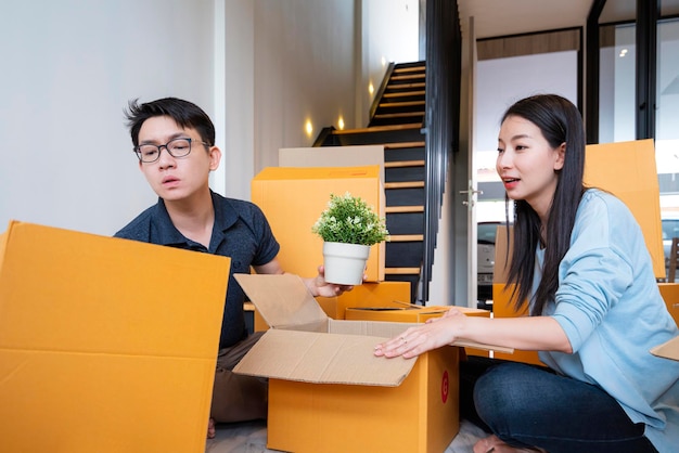Casa mudanza familia asiática marido esposa resuelve problema mientras desempaqueta cosas cosas