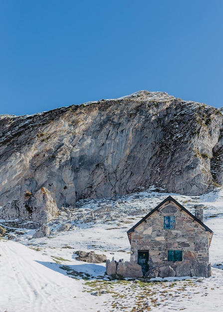 Casa de piedra gris construida a mano con rocas altas y hermoso cielo azul claro en el fondo