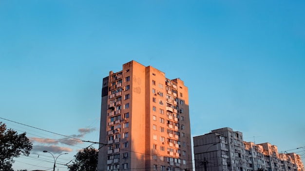 Casas de apartamentos envejecidos al atardecer con cielo azul