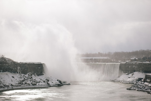 Cascada en invierno con árboles en el fondo en las Cataratas del Niágara en Ontario, Canadá