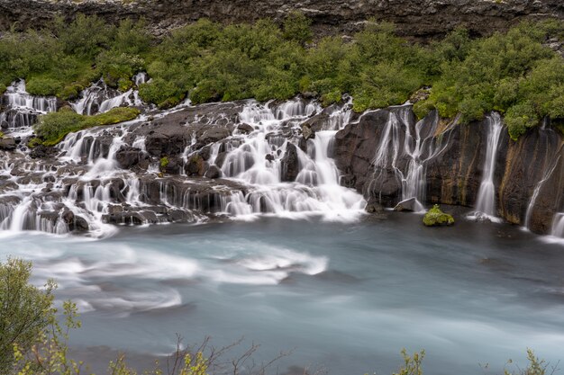 Cascadas de Hraunfossar rodeadas de vegetación durante el día en Islandia